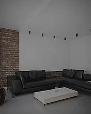 Microcemento nel salotto di una casa con mattoni a vista sul muro